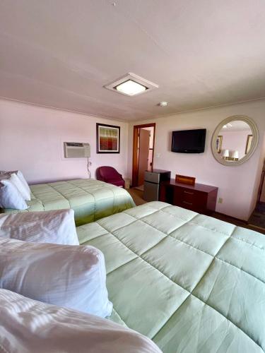 a hotel room with two beds and a mirror at Best Motel Bowling Green in Bowling Green