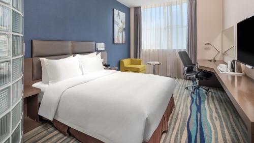 a large white bed in a hotel room at Holiday Inn Express Shenyang North Station by IHG in Shenyang