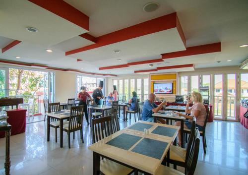 a restaurant with people sitting at tables in a room at Kiang Haad Beach Hua Hin in Hua Hin