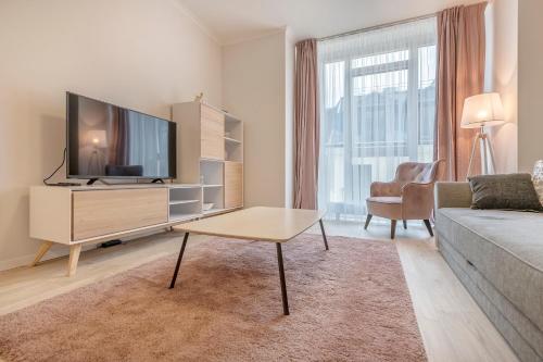a living room with a couch and a tv at HaPPy Inn Rich Studio, Self Check-In-24x7,Parking-in-the-underground-Garage in Vilnius