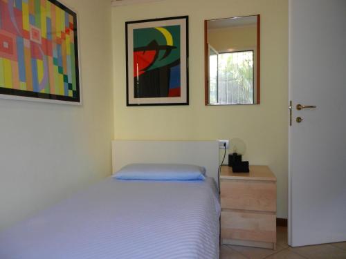 - une chambre avec un lit et deux photos sur le mur dans l'établissement Nora Casa Vacanze, à Dervio