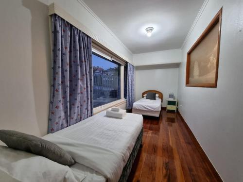 1 dormitorio con cama y ventana grande en Cozy 3BR Mt Roskill - Heat Pump & Wifi & Netflix en Auckland