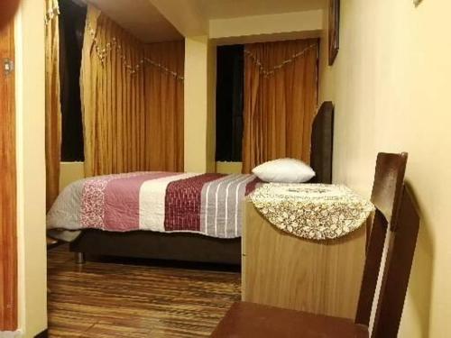 a bedroom with a bed and a chair in it at Hostal Inca in San Pedro
