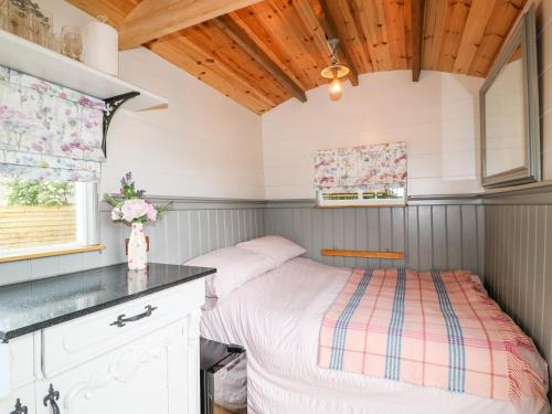 a small bedroom with a bed and a window at The Lazy Mare by The Water in Rugeley