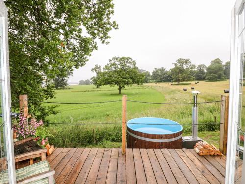 a wooden deck with a view of a field at The Lazy Mare by The Water in Rugeley