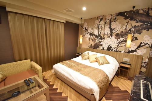 Habitación de hotel con cama y sofá en HOTEL IORI - Adult Only, en Kai