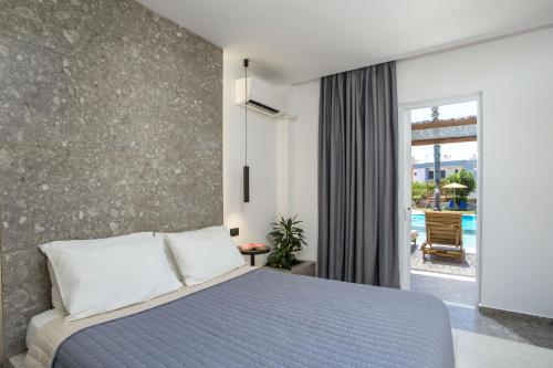 a bedroom with a blue bed and a balcony at Dias Studios & Suites in Faliraki