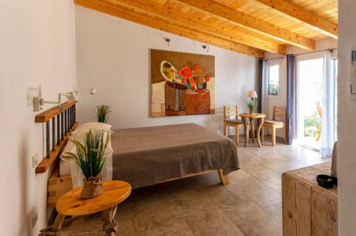 a bedroom with a bed and a table in a room at B&B Les Chambres Rooms & Suite in Santa Teresa Gallura