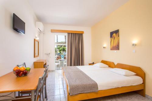 a hotel room with a bed and a table and a desk at Dias Studios & Suites in Faliraki