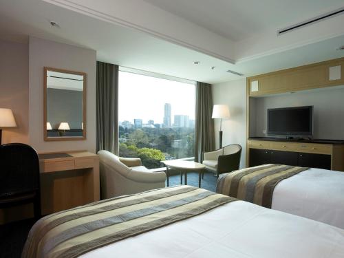 a hotel room with two beds and a television at Hotel New Otani Tokyo The Main in Tokyo