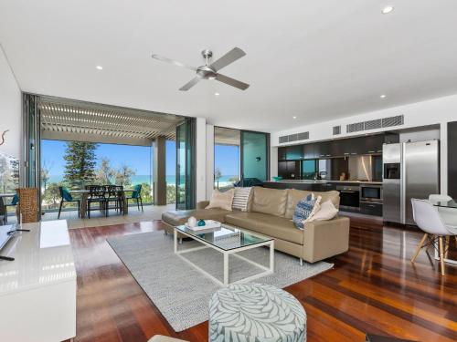 a living room with a couch and a table at Ocean Views at Nor Nor East 201 in Kingscliff