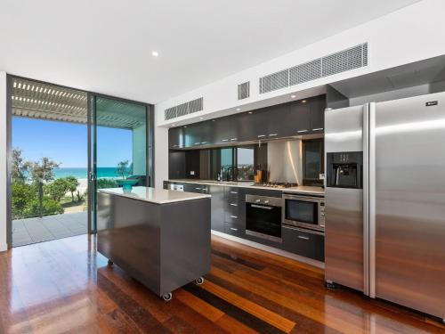 a kitchen with stainless steel appliances and a view of the ocean at Ocean Views at Nor Nor East 201 in Kingscliff