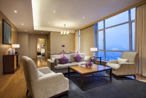 a living room with couches chairs and a table at Somerset Grand Central Dalian in Dalian