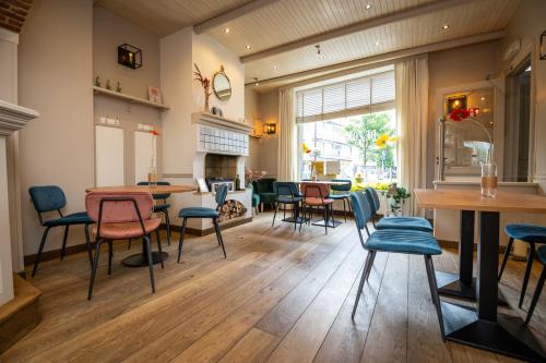 a living room with a table and chairs and a fireplace at De Zonnetuin in De Haan
