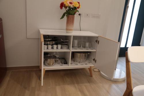 a cabinet with a vase of flowers on top of it at Chianca d l'ora - White Stone Suite in Ostuni