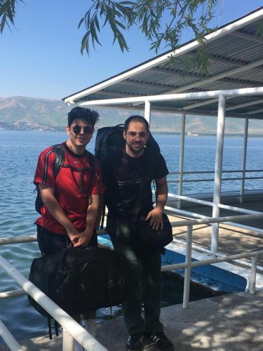 two men standing on a boat next to the water at EDEM SEVAN in Sevan