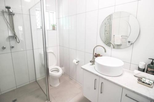 uma casa de banho com um WC, um lavatório e um chuveiro em ZEN GARDEN - COZY 2-BR + Modern Design w/ Aircon em Casuarina