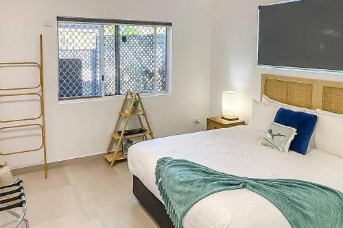 a bedroom with a large bed with a tv on the wall at ZEN GARDEN - COZY 2-BR + Modern Design w/ Aircon in Casuarina