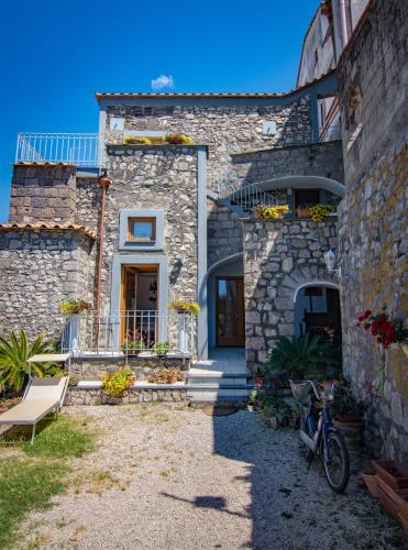 a stone house with a blue door and a porch at Villa Mariagiovanna - Casa Giovanna in Vico Equense