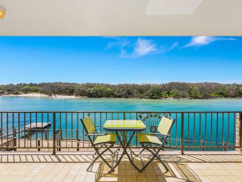 a table and chairs on a balcony with a view of the water at Creekfront Kingscliff Waters 2 in Kingscliff