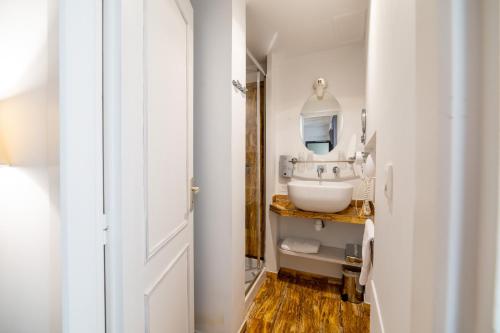 a bathroom with a sink and a mirror at Logis - Hotel De La Mairie in Embrun