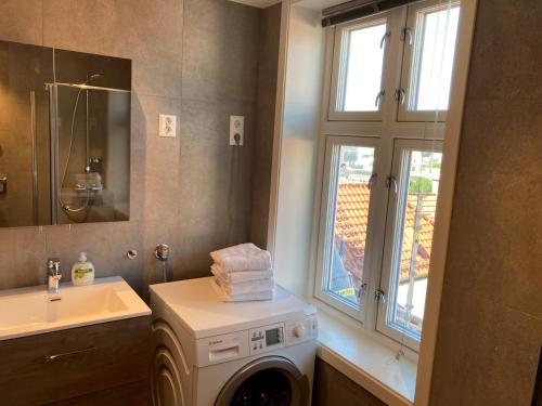 een badkamer met een wasmachine en een wastafel bij Skansen Apartments in Bergen