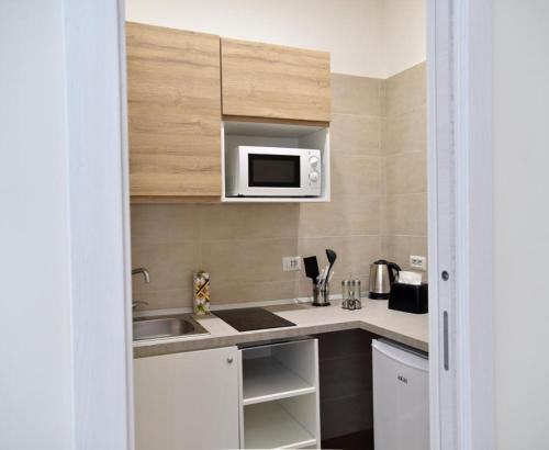 a kitchen with a sink and a microwave at Pompei Luxury Suite in Pompei