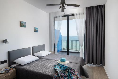een slaapkamer met 2 bedden en uitzicht op de oceaan bij Grand Dodo's Triada Seaview Studios in Agia Triada