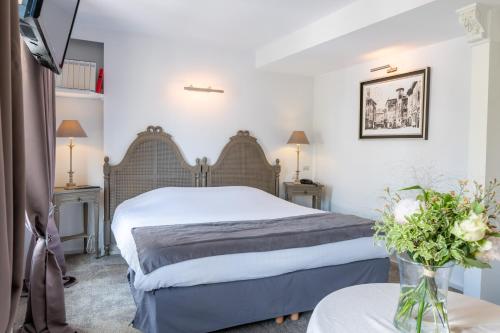 a hotel room with a bed and a table at Logis - Hotel De La Mairie in Embrun