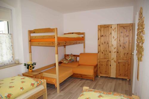 a bedroom with two bunk beds and a chair at Ferienwohnung KerMärchen in Gelenau