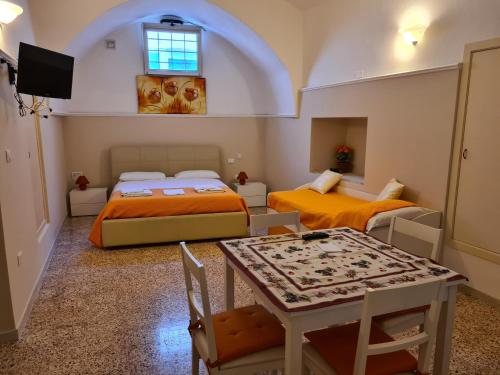 Habitación pequeña con 2 camas y mesa. en B&B Il Ventaglio, en Parabita