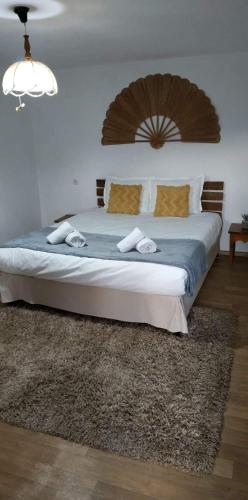 a bedroom with a large bed with a wooden headboard at Къща за гости Вила Отдих Vila Otdih in Apriltsi