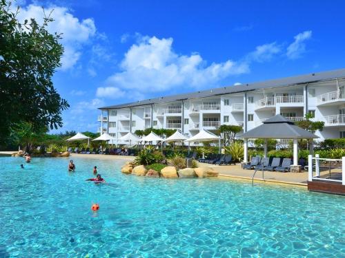 a hotel swimming pool with people in the water at RESORT ON THE BEACH 2214/2215 in Kingscliff