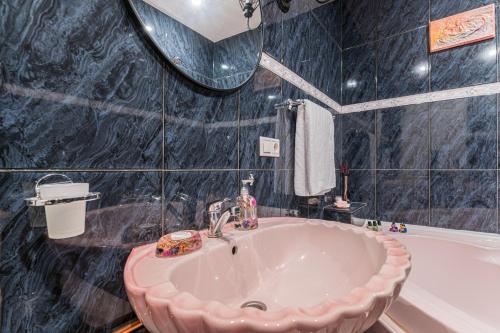 a bathroom with a sink and a bath tub at Sabin Apartments Private Parking in Braşov