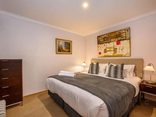 a bedroom with a large bed and a dresser at Lhotsky 8 in Thredbo