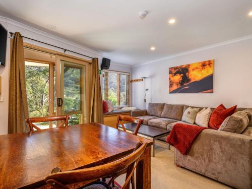 a living room with a table and a couch at Lhotsky 8 in Thredbo