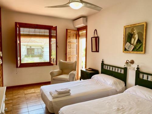 sypialnia z 2 łóżkami, krzesłem i oknem w obiekcie Precioso Chalet en Almuñecar junto al Mar con Garage privado w Almuñécar