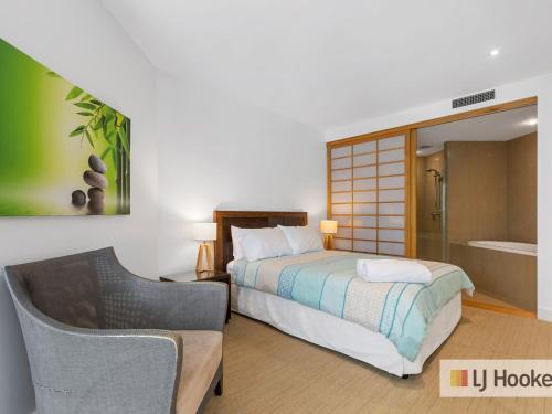 1 dormitorio con cama, silla y bañera en Cotton Beach 8 Escape With Private Plunge Pool en Casuarina
