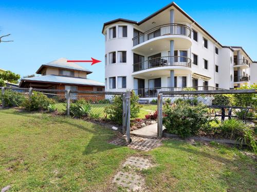a large white building with a yard in front of it at Shoreline 6 with Ocean Views To See The Whales in Hastings Point