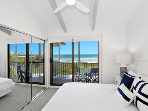 Un pat sau paturi într-o cameră la Sandpiper Beachfront House - Hastings Point