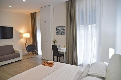 1 dormitorio con 1 cama y sala de estar con escritorio. en Pompei Luxury Suite en Pompei