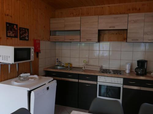 a small kitchen with a sink and a microwave at Ferienhäuser mit Pool in Rewal