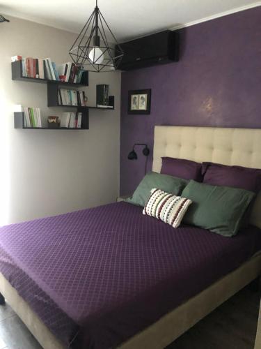 - une chambre violette dotée d'un lit avec un mur violet dans l'établissement Bel appartement au calme vue imprenable parking privé gratuit, à La Ciotat