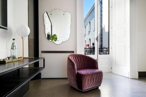 a purple chair in a room with a table at Palazzo De Noha - Boutique Hotel in Lecce