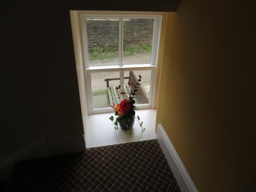 a window with a vase of flowers in a room at The Roebuck Inn in Chapel en le Frith