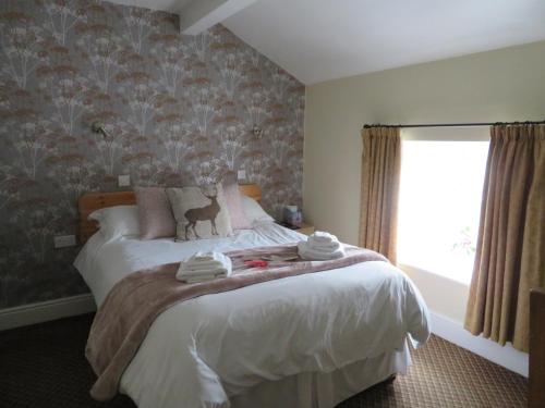 a bedroom with a bed with towels on it at The Roebuck Inn in Chapel en le Frith