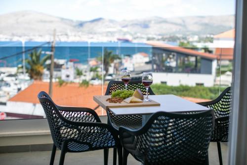 a table with a plate of food and two glasses of wine at Enjoy Trogir Ciovo in Trogir