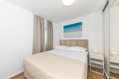 a white bedroom with a bed and a window at Enjoy Trogir Ciovo in Trogir
