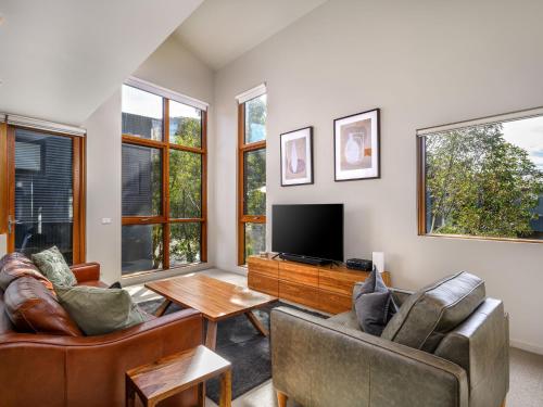 a living room with two chairs and a television at Snow Stream 5 in Thredbo