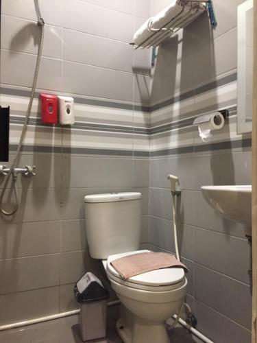 a bathroom with a toilet and a sink at RedDoorz Plus @ Hotel Alden Makassar in Makassar